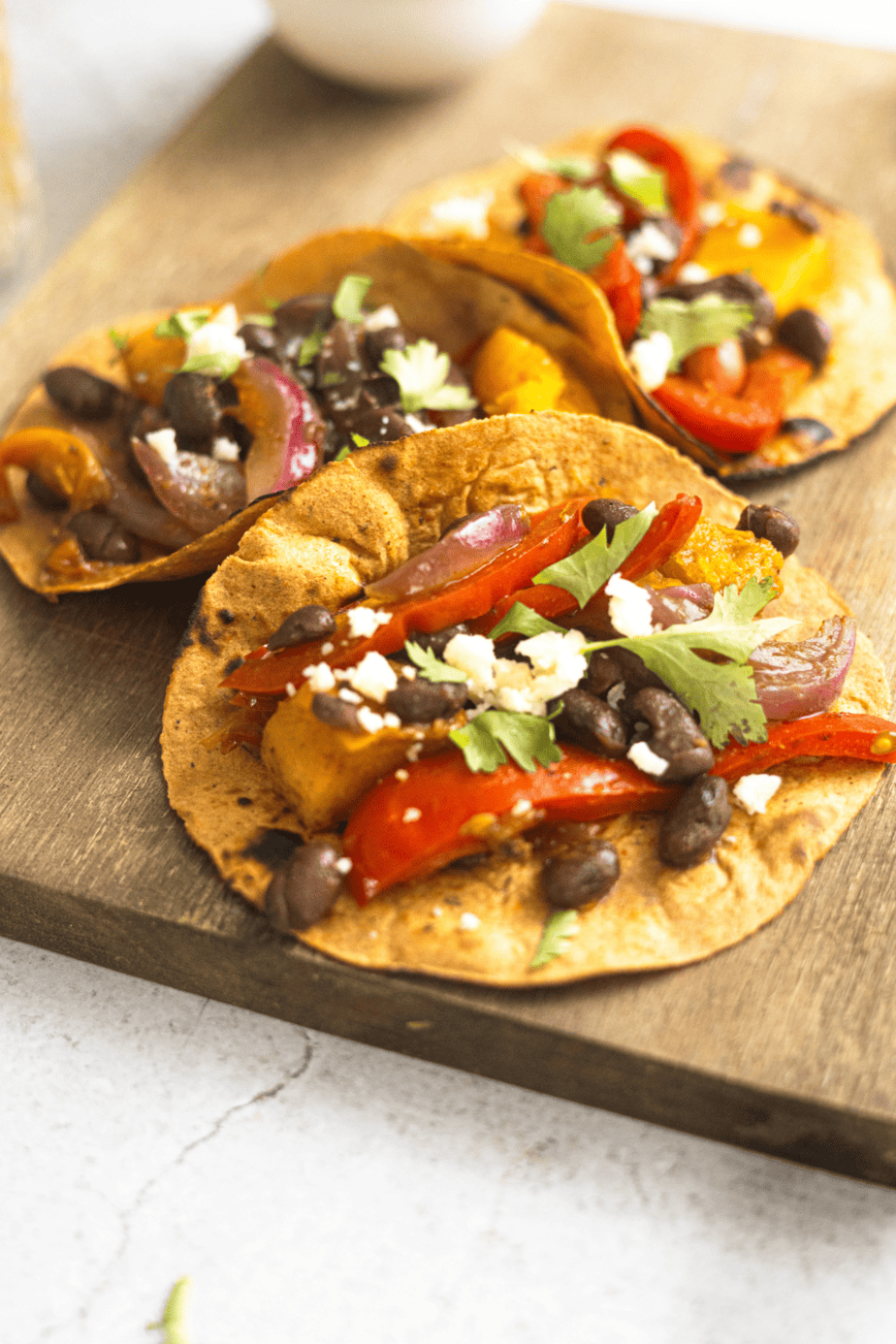butternut squash tacos on a wooden cutting board up close to show all vegetables and beans