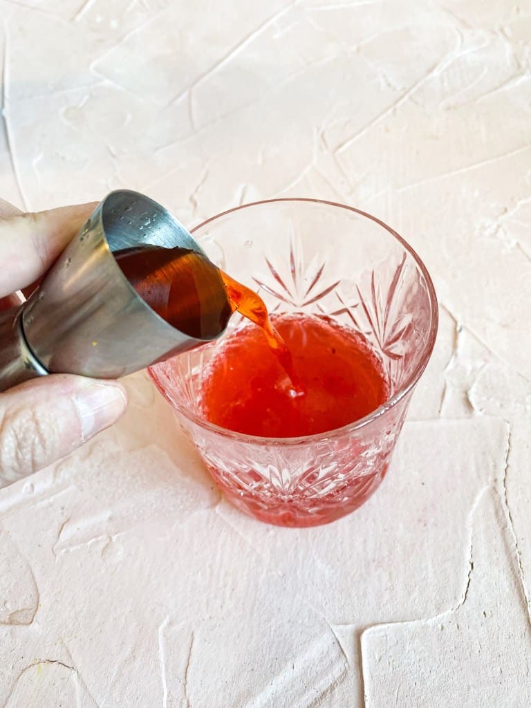 Pouring aperol into cup