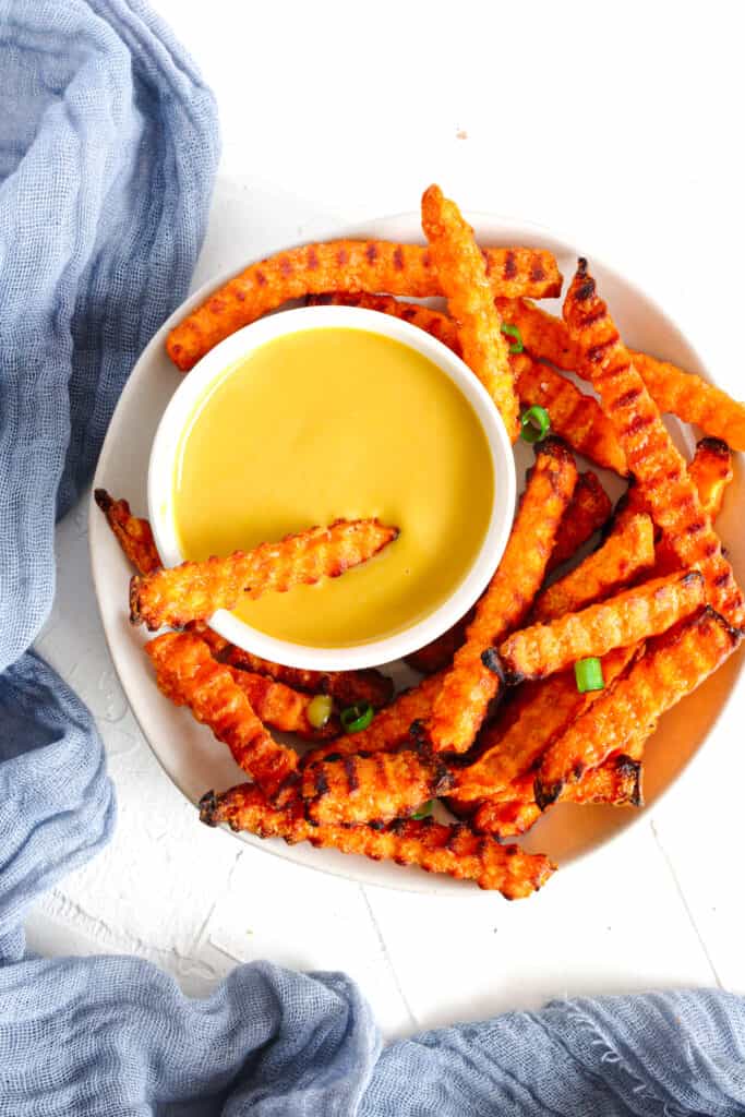 Dairy Free Dip (Honey Mustard) in a small white bowl with sweet potato fries surronding it