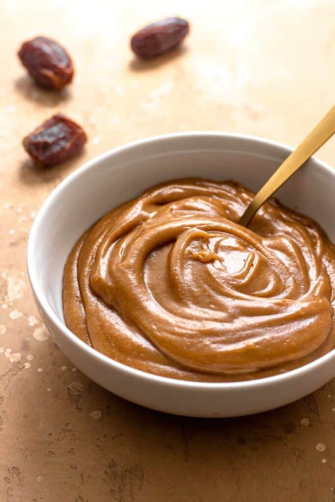 Caramel Dairy Free Dip in a white bowl with a wood backdrop