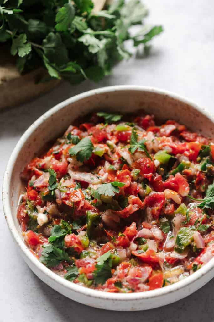 Grape tomato salsa in a bowl with a gray background