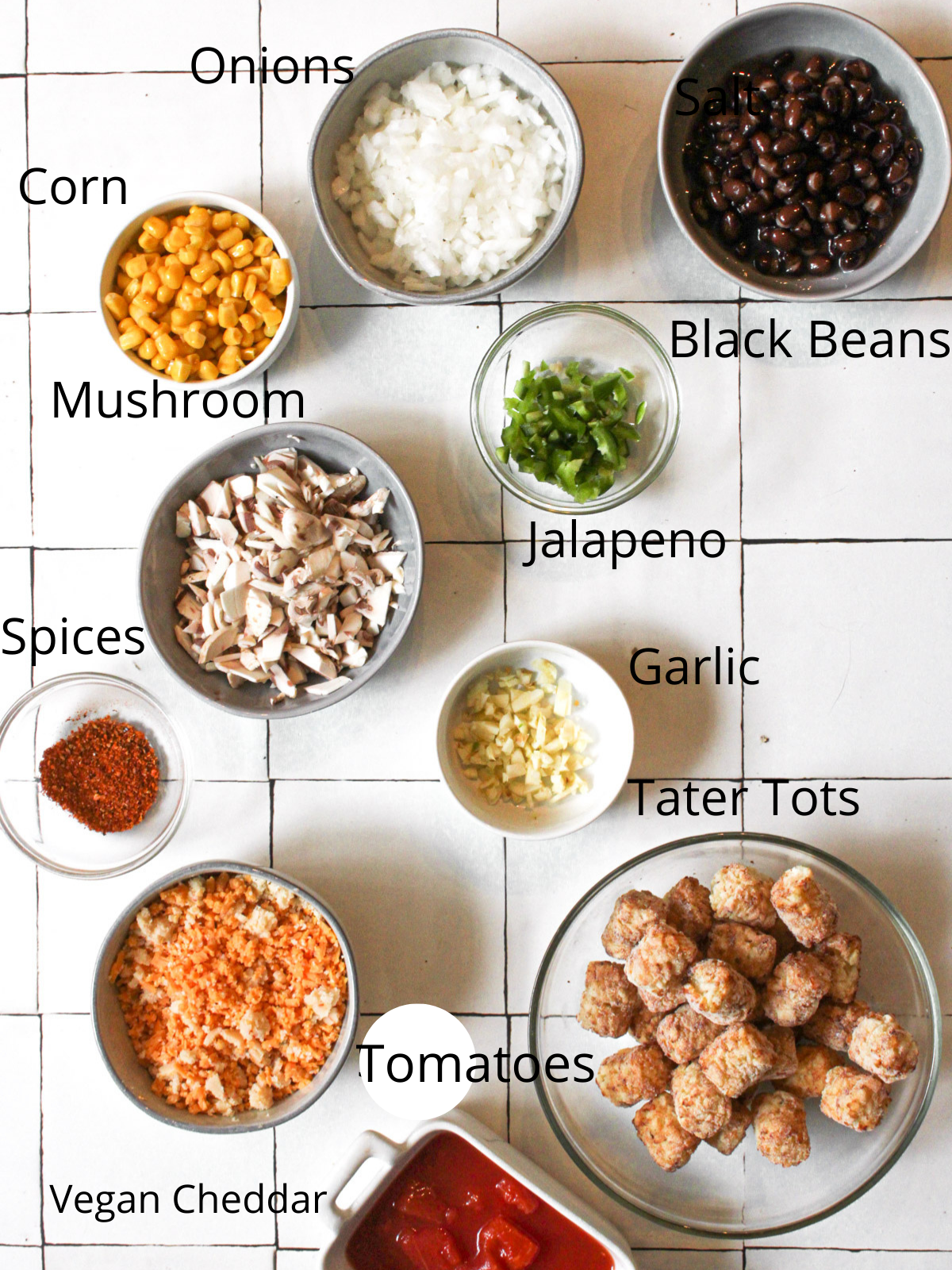 ingredients needed for vegan tater tot casserole: onions, corn, black beans, mushrooms, jalapeño, garlic, spices, vegan cheddar, salsa, and tater tots