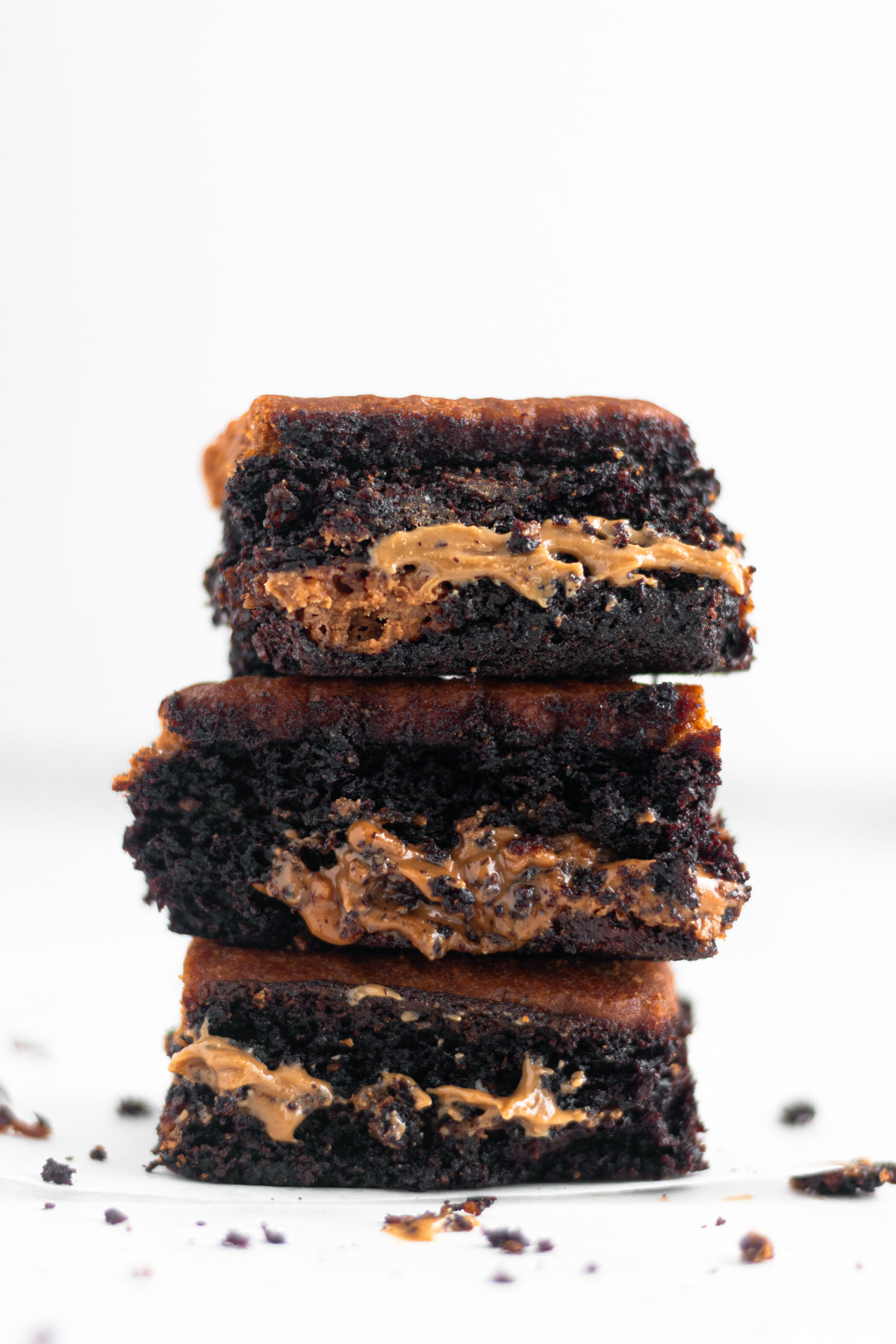 Vegan Biscoff Brownie on parchment paper with three brownies stacked on top of each other close up 