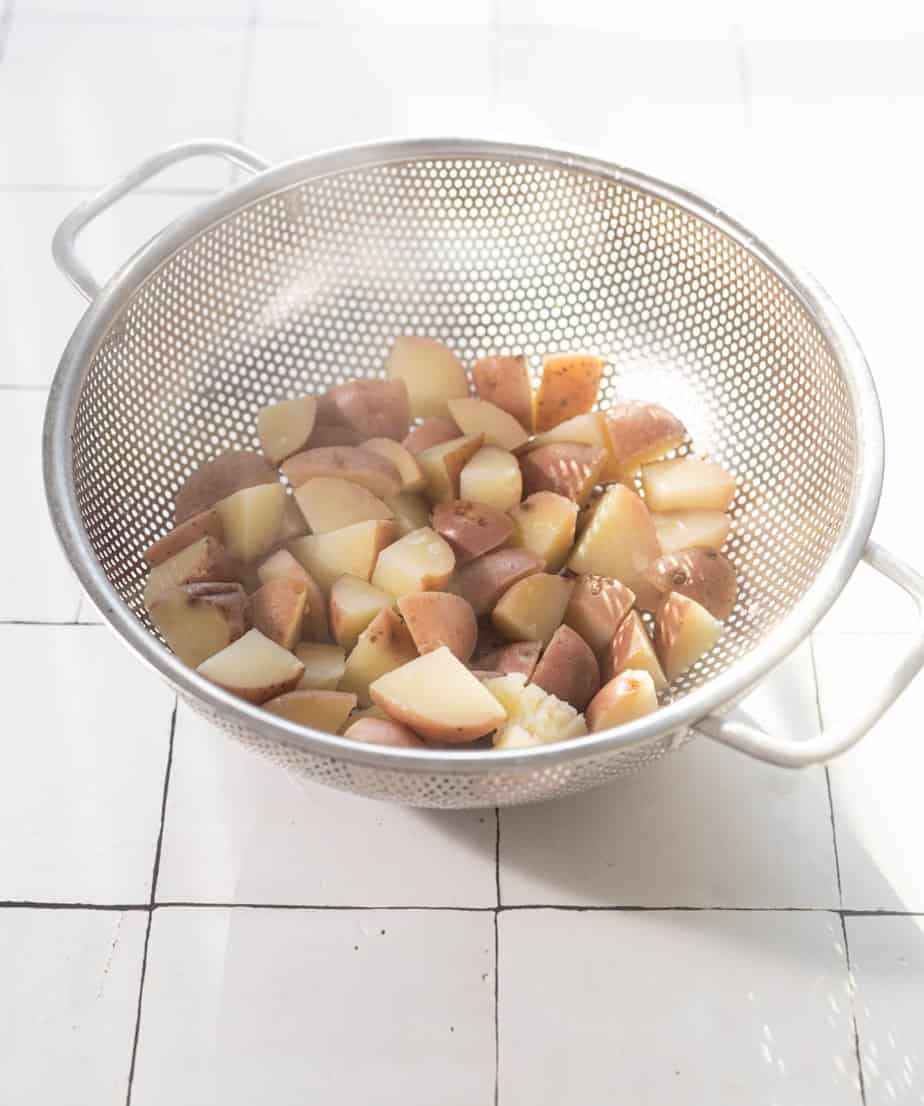cooked potatoes in a metal strainer 