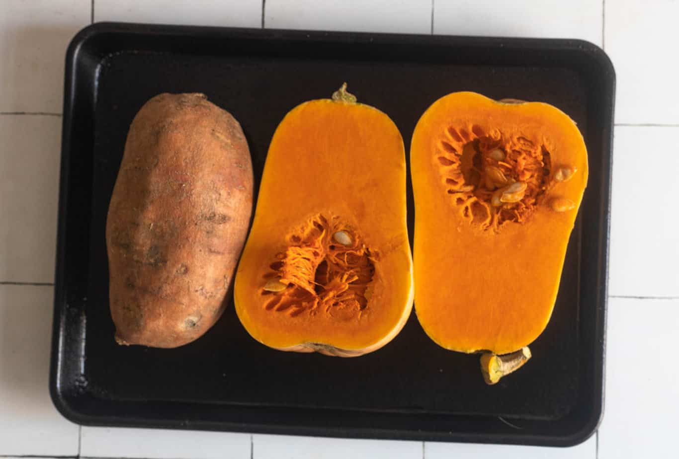 The sweet potato and butternut squash on a baking sheet before baking