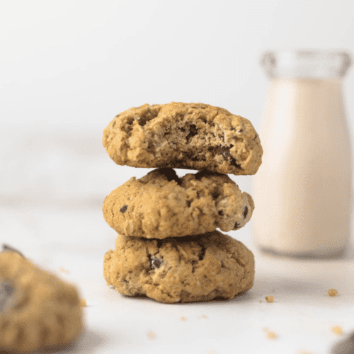 Dairy free oatmeal chocolate chip cookie in a stack with a glass of milk in background