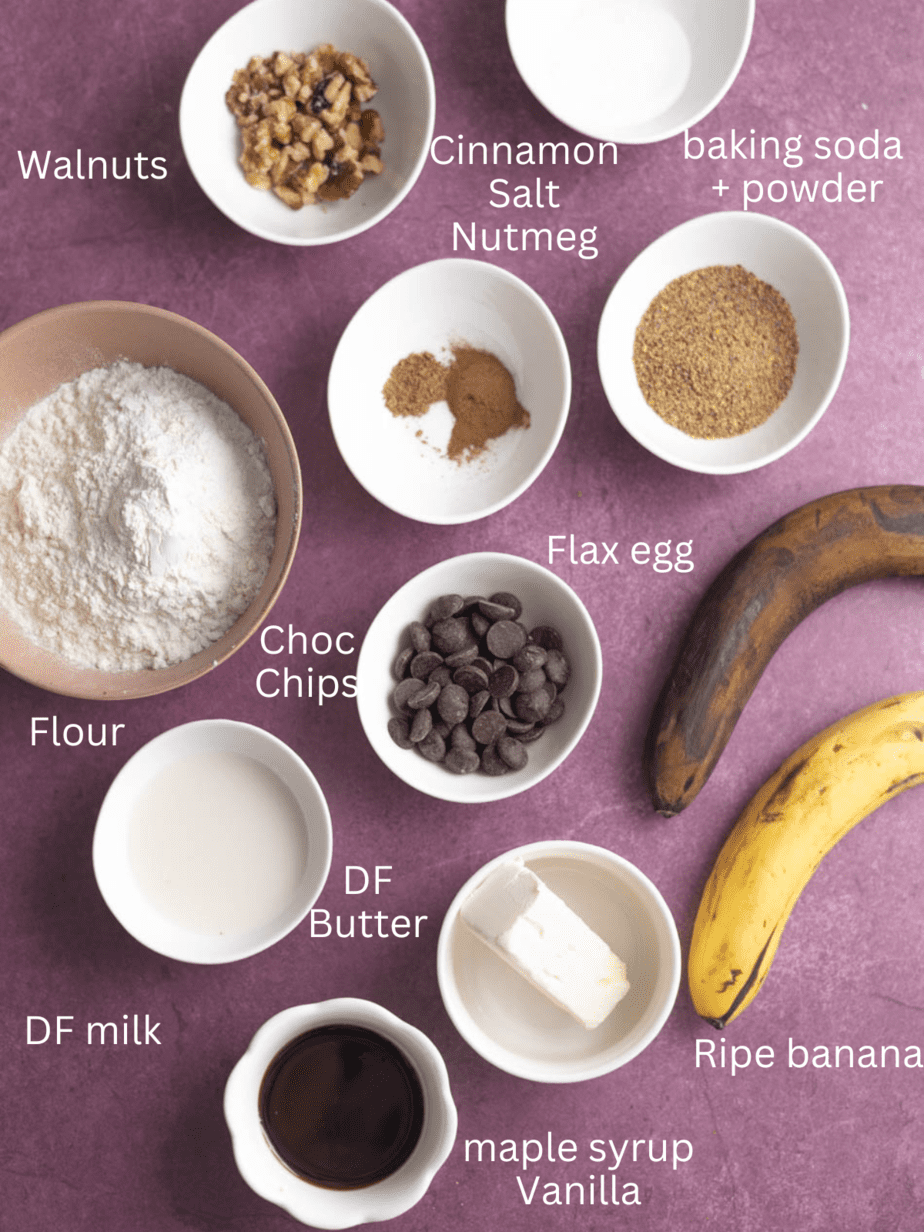 All ingredients for banana bread on a purple backdrop with labels for each ingredients