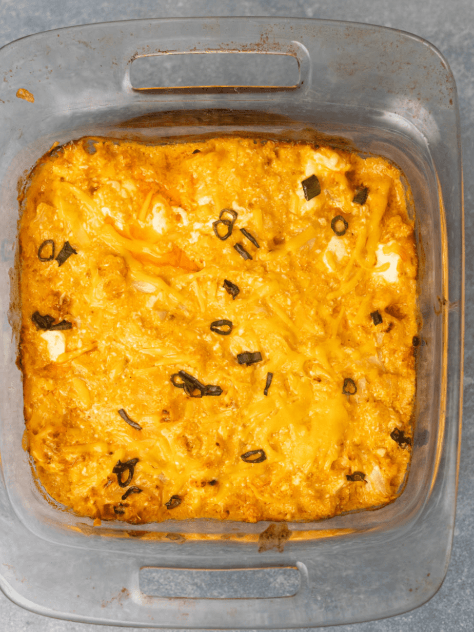 Buffalo dip after being baked in a casserole dish with melted cheese and chives on top