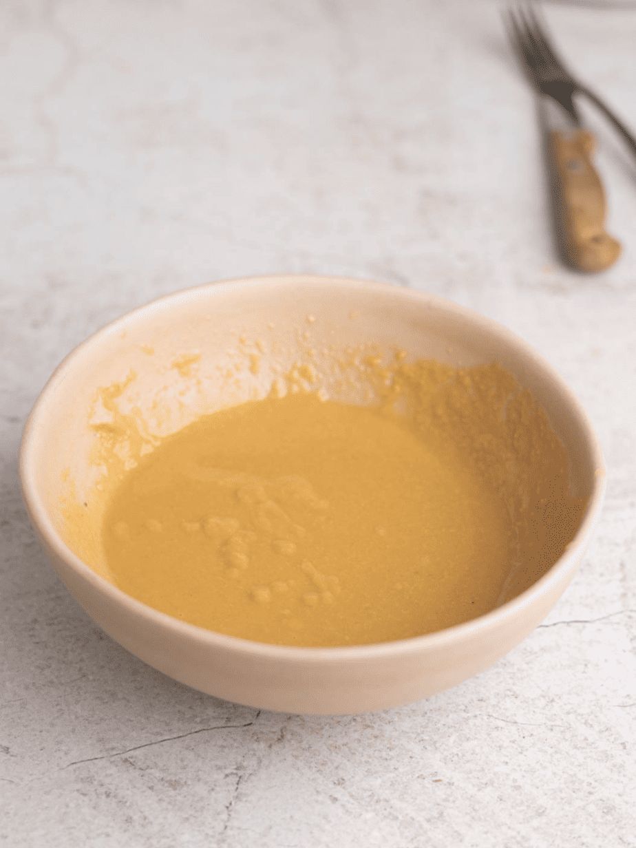 miso tahini dressing all mix together in a pink bowl