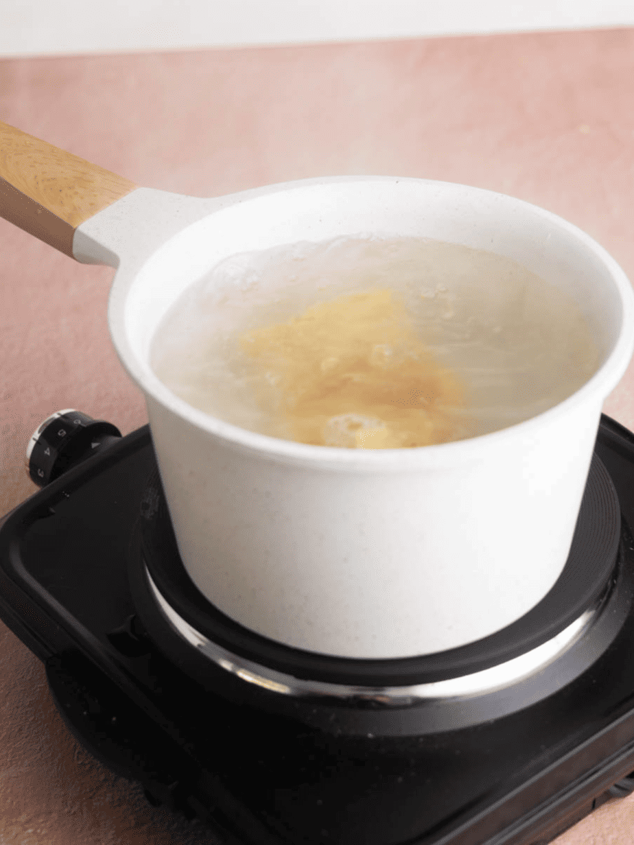 pasta in a boiling pot of water on a hot plate