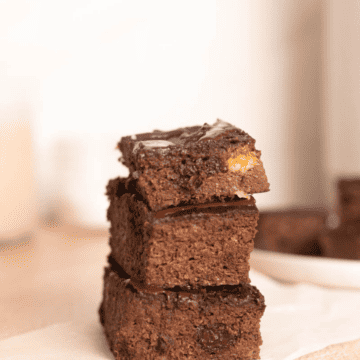Healthy banana brownies (3) stacked on top of each other on parchment paper