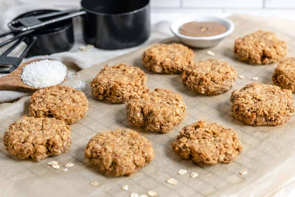 coconut oatmeal cookies on parchment paper with oats next to them